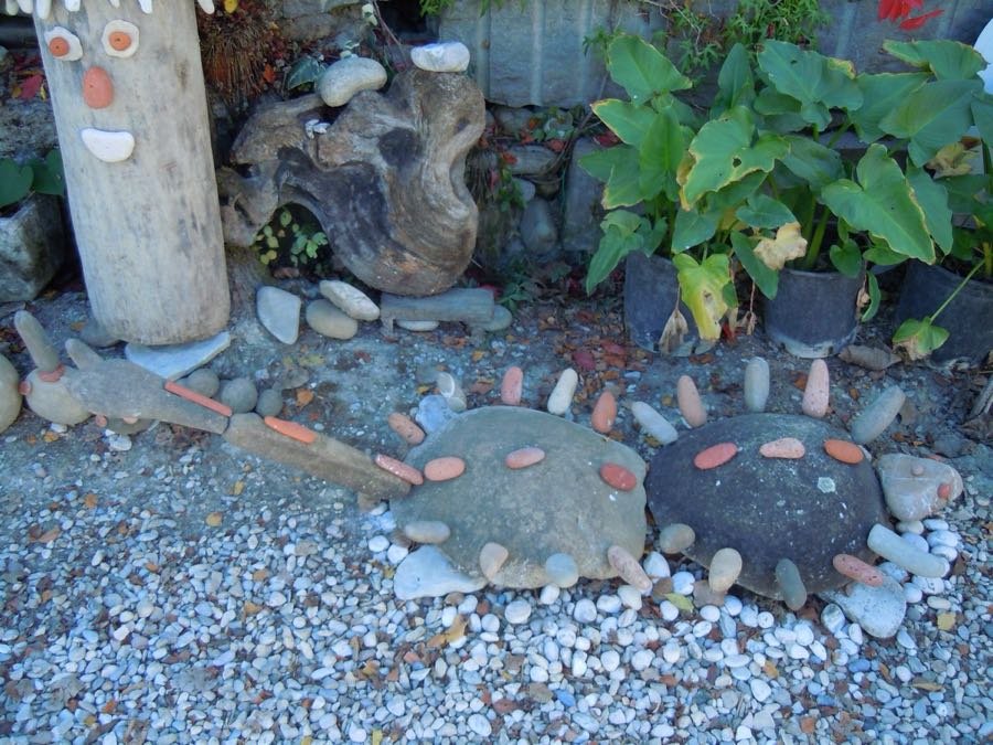 Due piccole sculture di tartaruga con macchie arancioni, accanto a un totem di legno