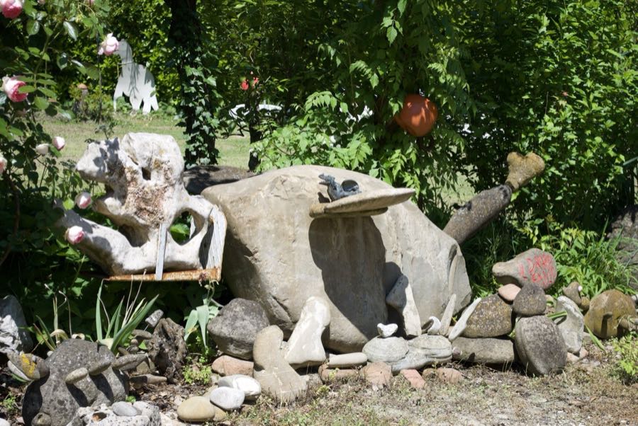 Scultura di pietra con una piccola figura di drago, accanto a un sasso con scritto IL DRAGO EMILIO