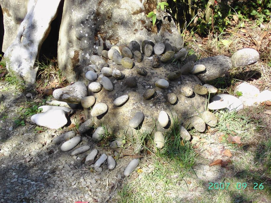 Scultura di sasso con la schiena coperta da file di piastre tonde, foto del 2007
