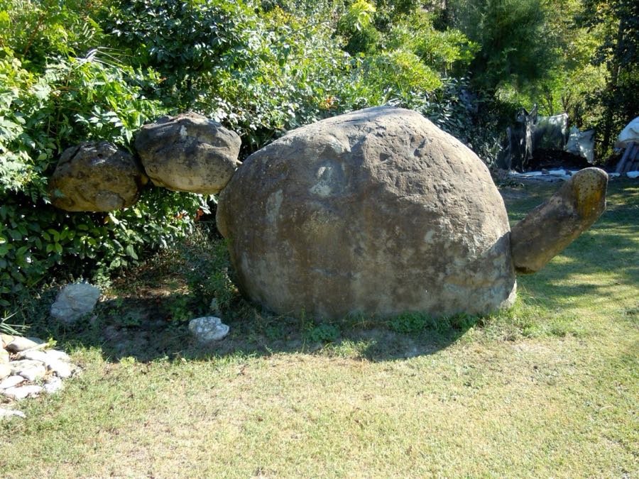 Grande scultura di tartaruga fatta con un masso tondeggiante, testa e zampe di pietra